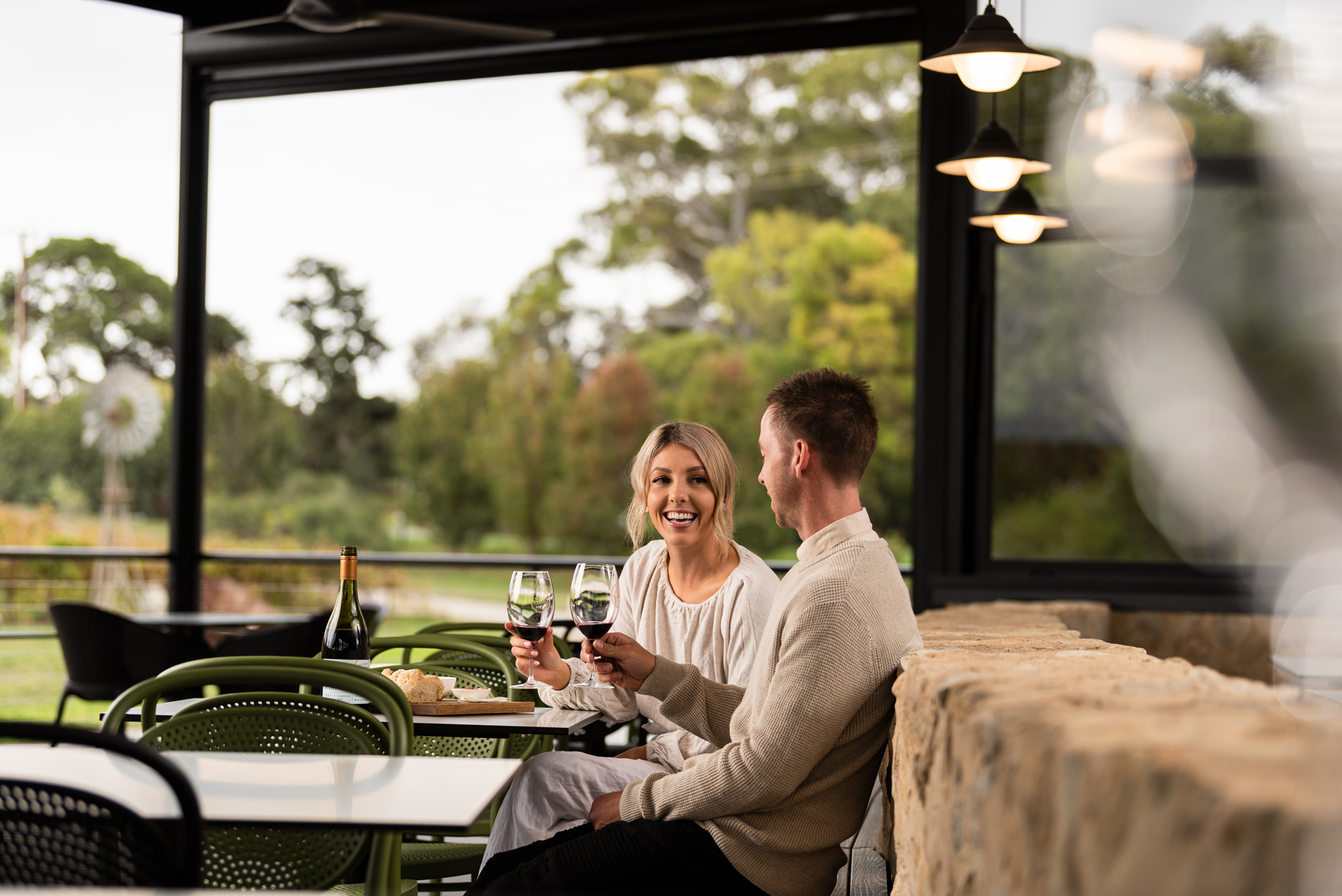 Couple sitting in winery patio drinking wine 